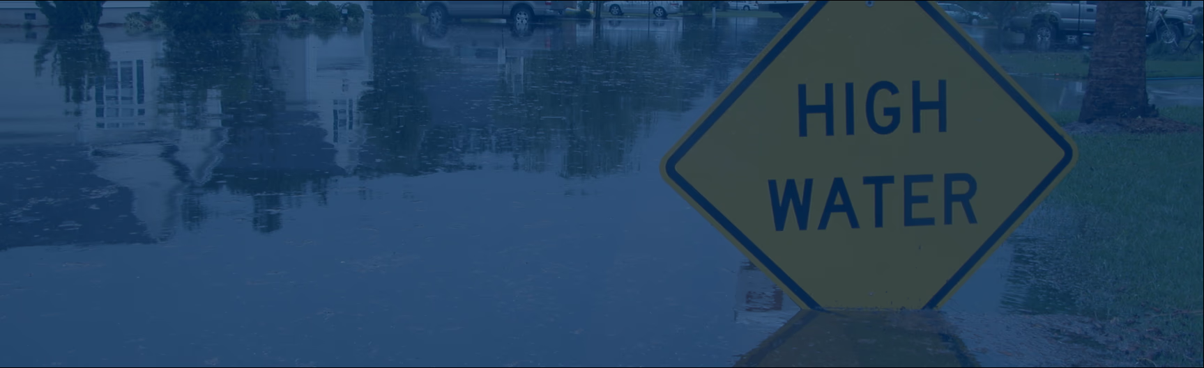 high water sign in flooded neighborhood