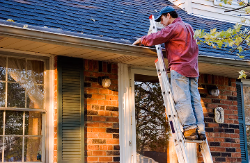homeowner cleaning out gutter