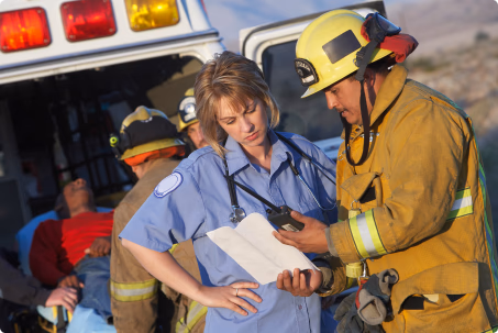 Firefighter and paramedic in discussion at an emergency site