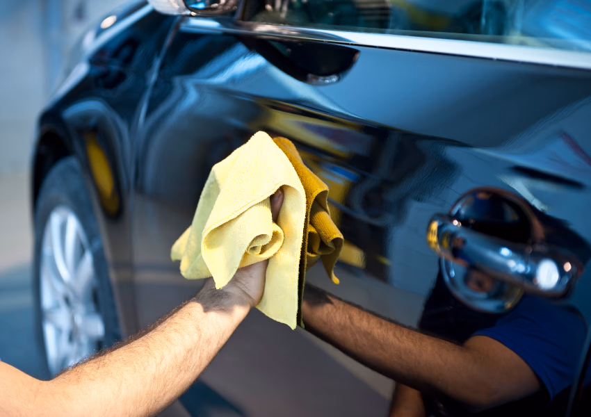 person buffing car with chamois