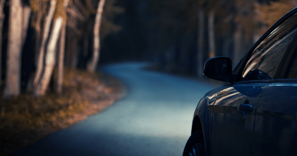vehicle driving down dark road