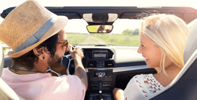 man and woman in car smiling at each other