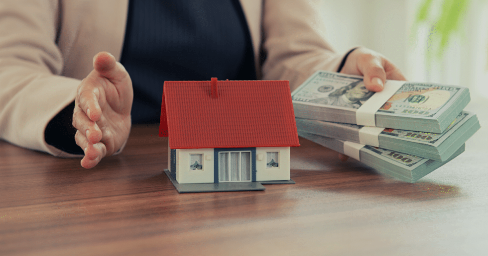 hands holding money and a miniature house