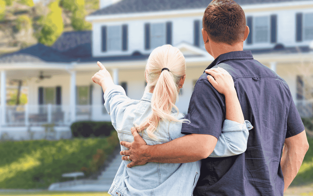 couple, with woman pointing at home exterior