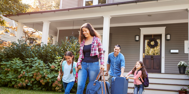 Family Leaving House with Suitcases