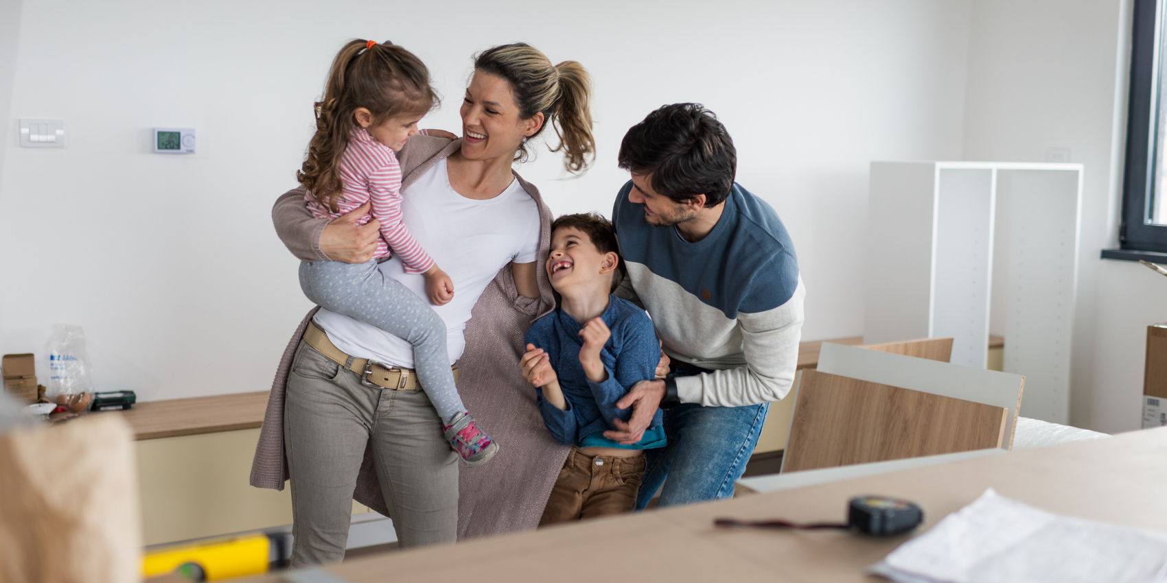 Family smiling in room under renovation